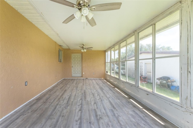 unfurnished sunroom featuring ceiling fan