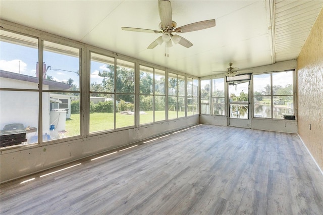 unfurnished sunroom with ceiling fan