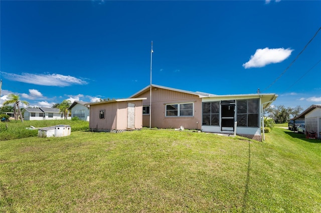 back of property with a sunroom and a lawn