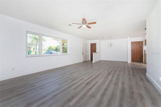 unfurnished living room featuring ceiling fan with notable chandelier and wood-type flooring