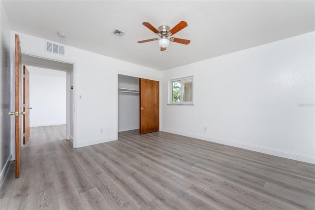 unfurnished bedroom featuring light hardwood / wood-style flooring, a closet, and ceiling fan