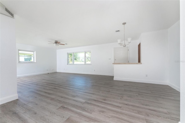 unfurnished living room featuring hardwood / wood-style flooring and ceiling fan with notable chandelier