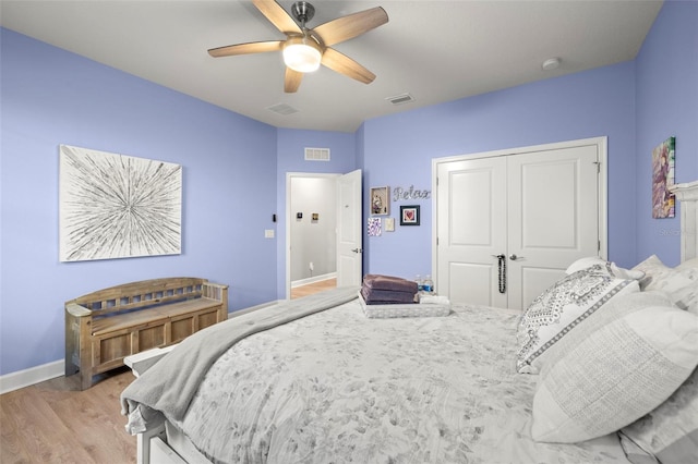 bedroom with ceiling fan, light hardwood / wood-style floors, and a closet