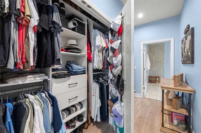 walk in closet with light hardwood / wood-style floors