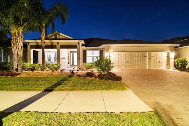 view of front of home with a garage and a lawn