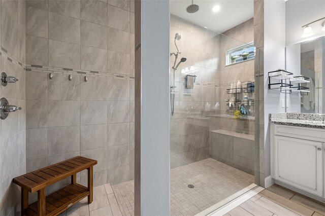 bathroom with vanity and a tile shower