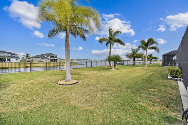 view of yard featuring a water view and glass enclosure