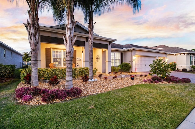 view of front of property with a garage and a lawn