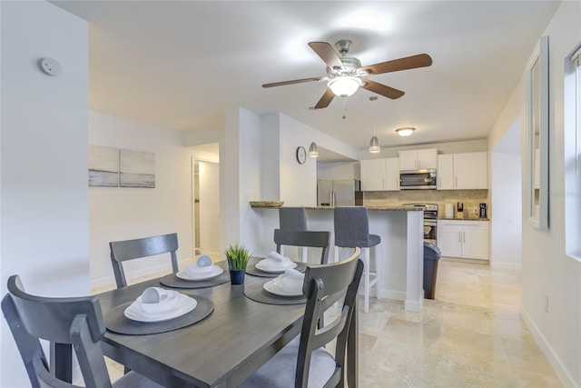 dining space with light tile patterned floors and ceiling fan