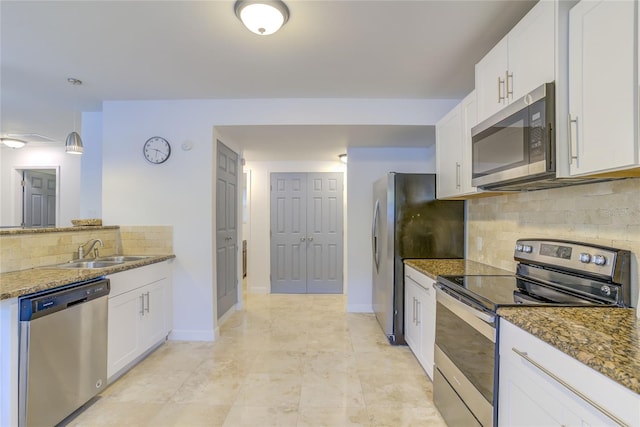 kitchen with white cabinetry, stainless steel appliances, backsplash, and stone counters