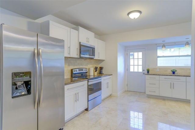 kitchen featuring white cabinets, stainless steel appliances, and backsplash