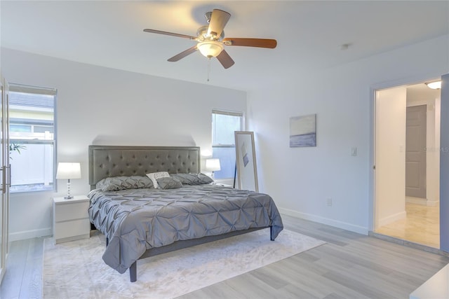 bedroom with light hardwood / wood-style flooring, multiple windows, and ceiling fan