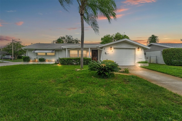 ranch-style house featuring a garage and a yard