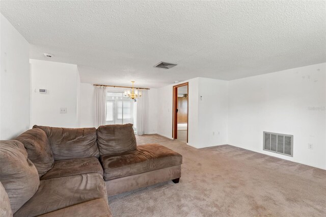 carpeted living room with an inviting chandelier and a textured ceiling