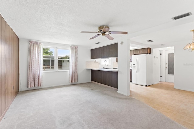 7015 Flaggler Dr, Port Richey, FL 34668 - unfurnished living room with light colored carpet, wooden walls, ceiling fan, and visible vents
