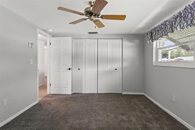 unfurnished bedroom with a closet, ceiling fan, and dark colored carpet