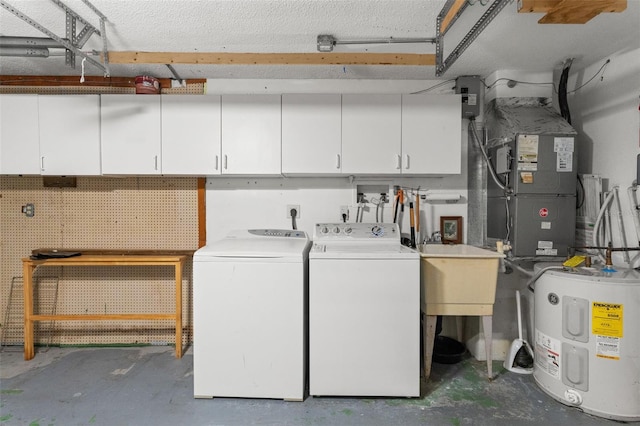 laundry room featuring water heater, sink, cabinets, washer and clothes dryer, and a workshop area