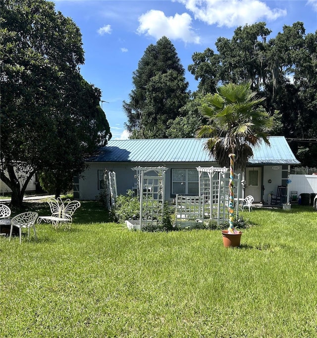 view of front facade featuring a front yard and metal roof