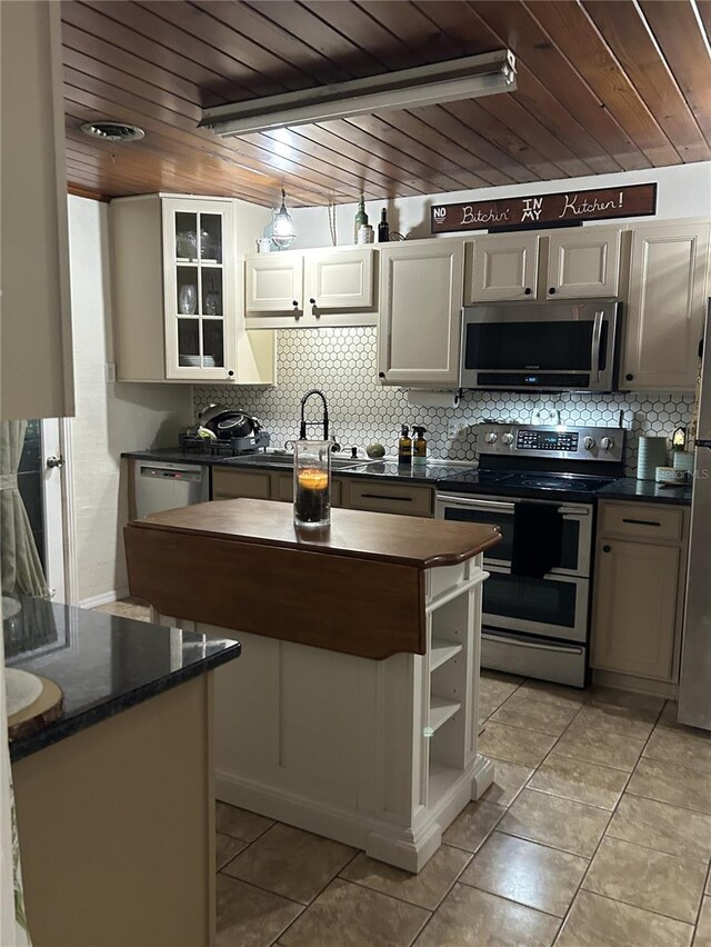 kitchen with appliances with stainless steel finishes, wooden ceiling, and light tile patterned floors