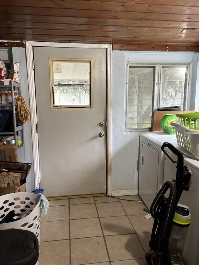 laundry area with wooden ceiling, washer and dryer, and light tile patterned floors