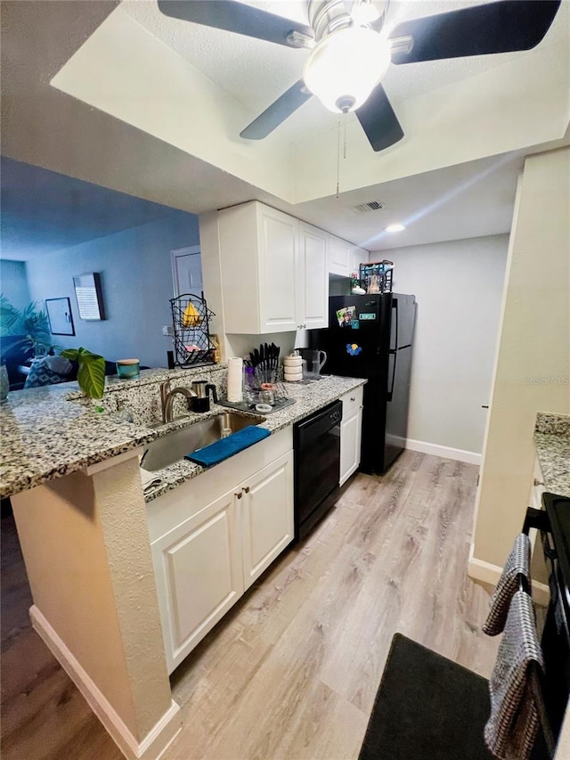 kitchen with sink, light wood-type flooring, light stone countertops, ceiling fan, and black appliances