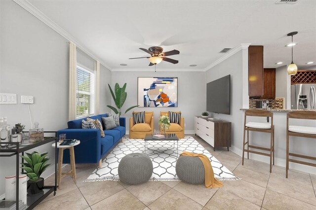 living area featuring light tile patterned floors, ceiling fan, visible vents, and crown molding