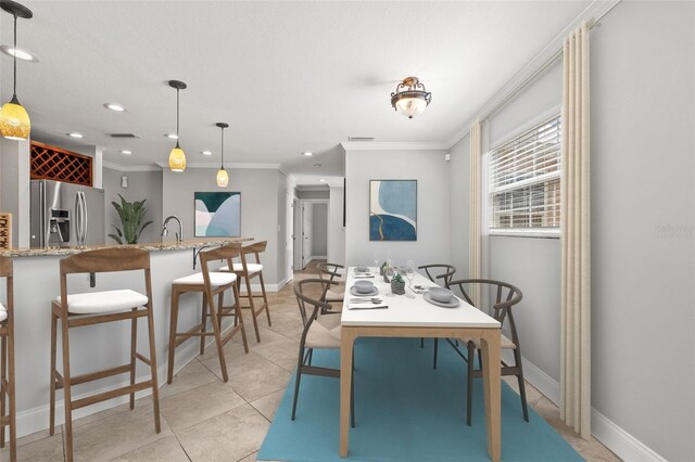 dining area featuring indoor wet bar, recessed lighting, ornamental molding, light tile patterned flooring, and baseboards