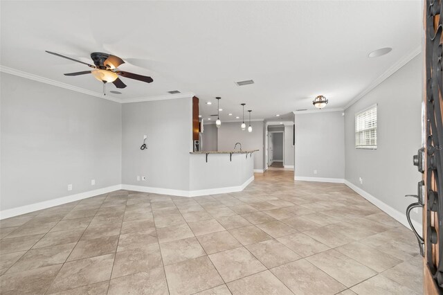 unfurnished living room with ceiling fan, baseboards, and crown molding