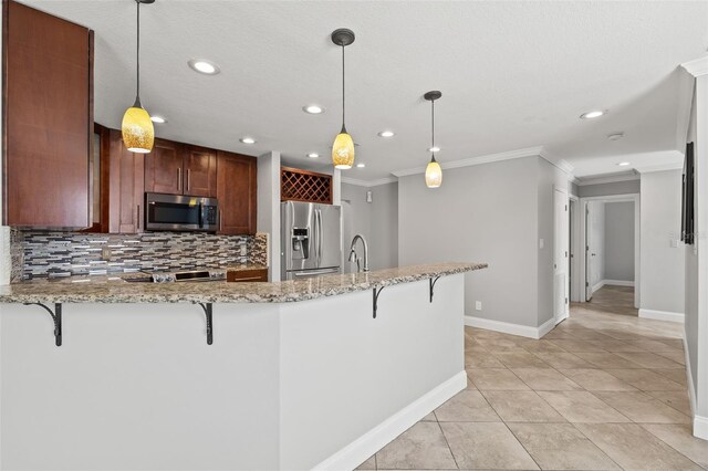 kitchen with tasteful backsplash, a breakfast bar area, appliances with stainless steel finishes, a peninsula, and crown molding