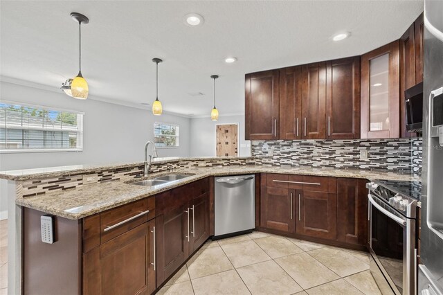 kitchen with appliances with stainless steel finishes, a sink, a peninsula, and tasteful backsplash