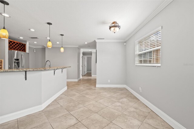 kitchen featuring baseboards, stainless steel fridge with ice dispenser, ornamental molding, a breakfast bar, and light stone counters