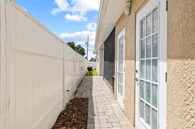 view of side of home featuring a fenced backyard and stucco siding