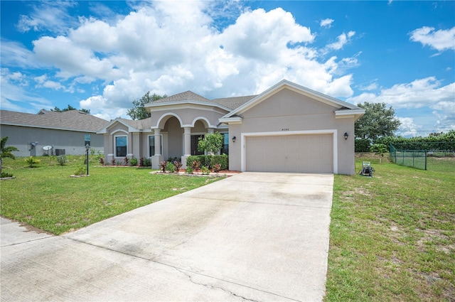 mediterranean / spanish-style home featuring an attached garage, driveway, a front lawn, and stucco siding