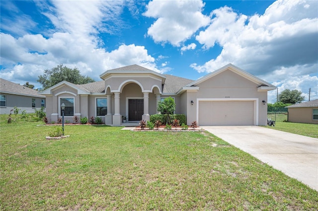 view of front of property with concrete driveway, a front lawn, an attached garage, and stucco siding