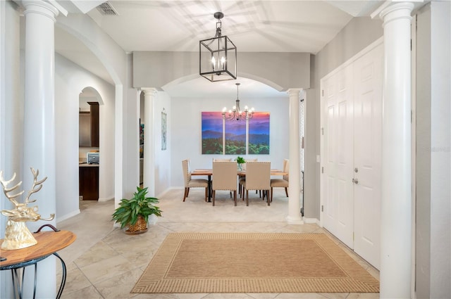 tiled dining area featuring an inviting chandelier and decorative columns