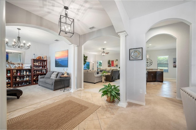 living room with ceiling fan with notable chandelier, ornate columns, and light tile patterned floors