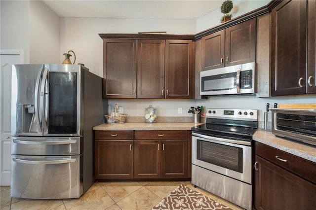 kitchen featuring dark brown cabinetry, appliances with stainless steel finishes, and light tile patterned floors