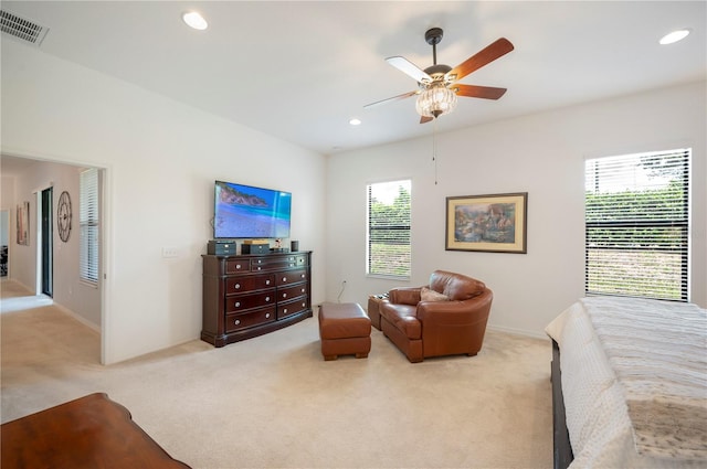 bedroom featuring multiple windows, ceiling fan, and light colored carpet