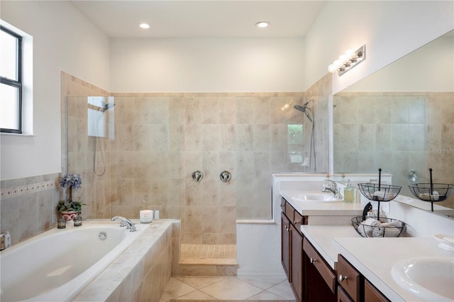 bathroom with tile patterned flooring, tile walls, separate shower and tub, and dual bowl vanity