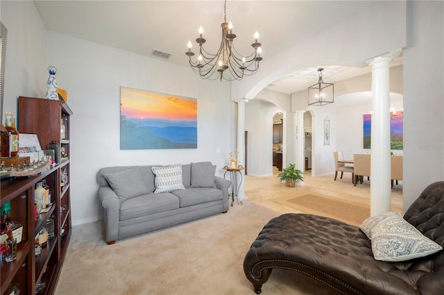 living room with a notable chandelier, decorative columns, and light colored carpet