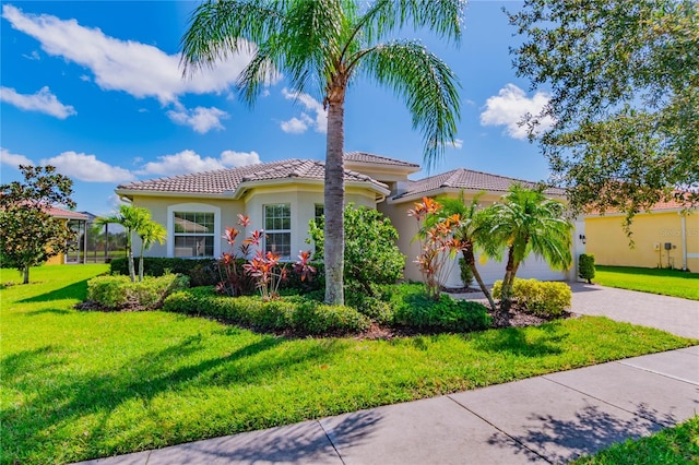 mediterranean / spanish house with a garage and a front lawn