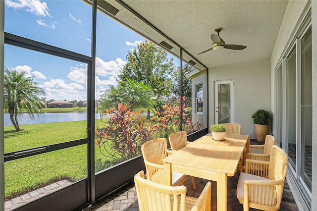 sunroom with a water view, ceiling fan, and plenty of natural light