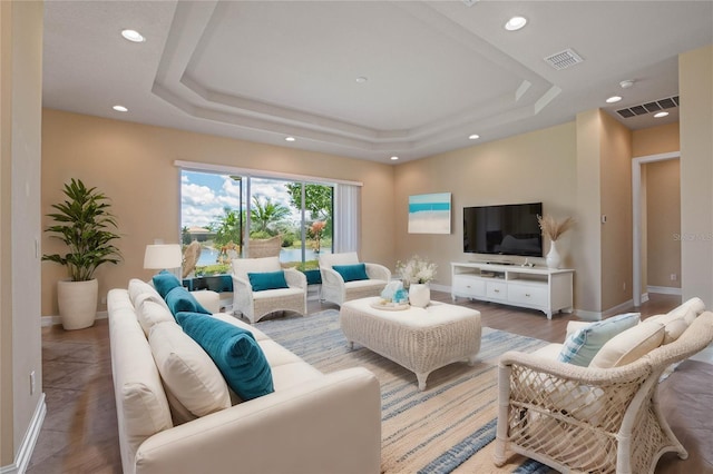 living room with wood-type flooring and a raised ceiling