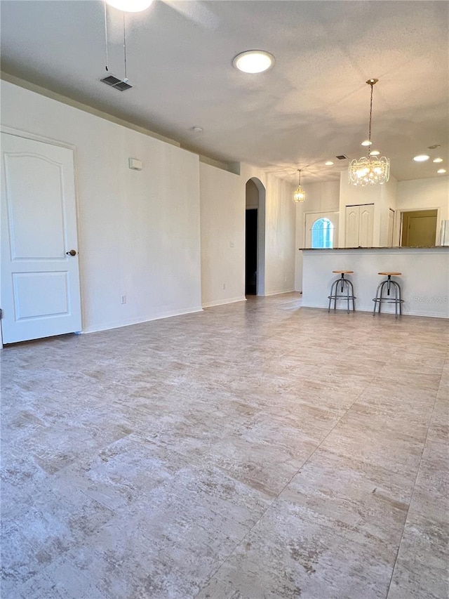 unfurnished living room with an inviting chandelier