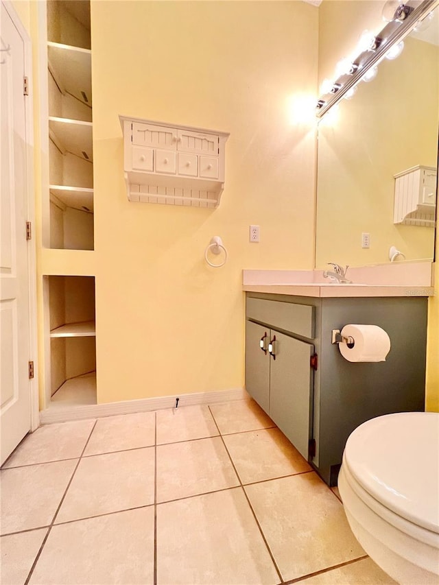 bathroom featuring tile patterned flooring, vanity, built in shelves, and toilet