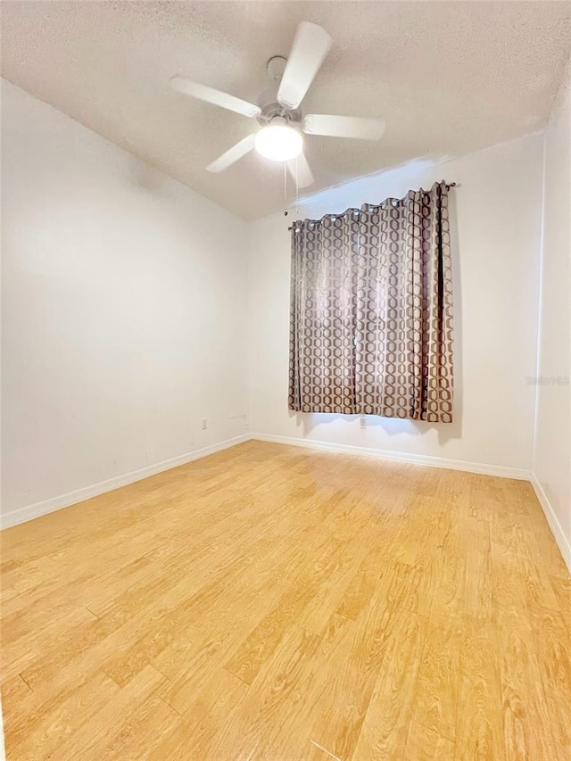 empty room featuring ceiling fan, a textured ceiling, and light wood-type flooring