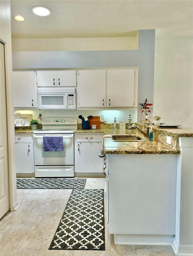 761 Tremont Greens Ln Unit 61, Sun City Center, FL 33573 - kitchen with a sink, a peninsula, white appliances, light stone counters, and white cabinetry