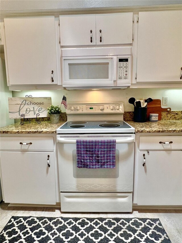 761 Tremont Greens Ln Unit 61, Sun City Center, FL 33573 - kitchen featuring white appliances, white cabinets, and light stone countertops