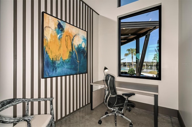 home office with concrete floors and baseboards