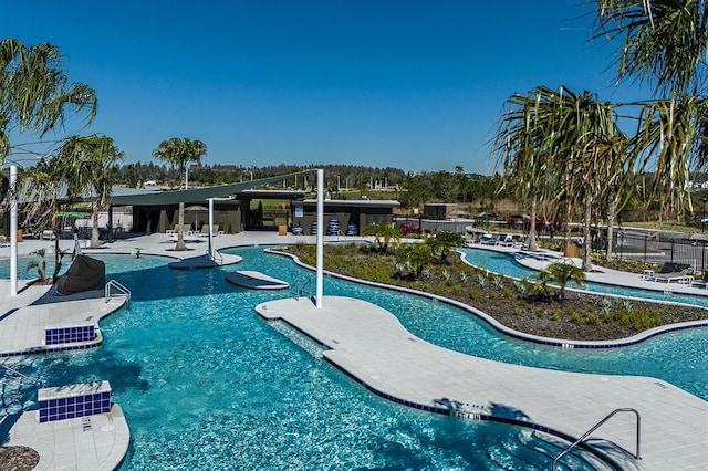 community pool with a patio area and fence